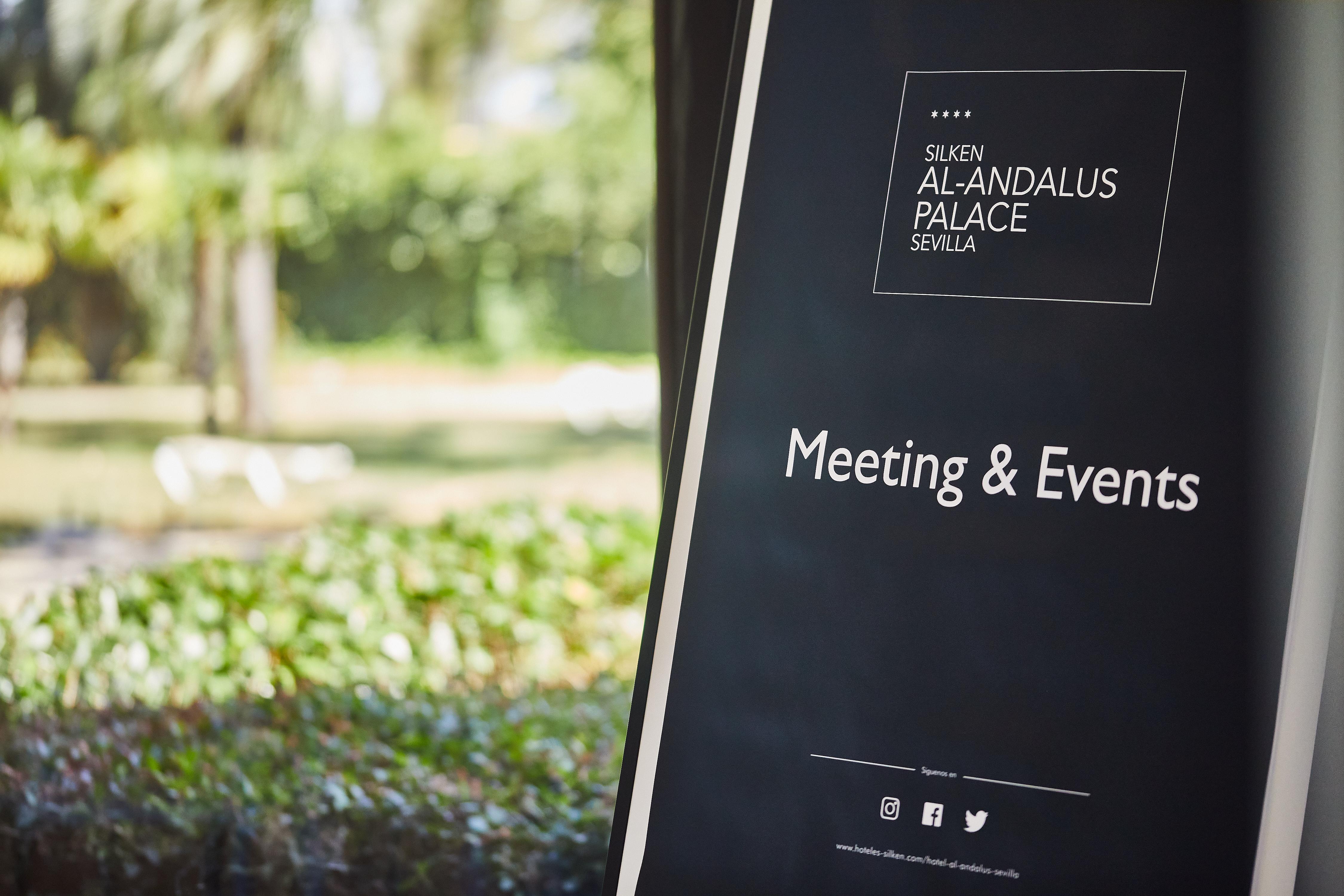 Silken Al-Andalus Palace Sevilla Exterior foto The photo displays a sign for "Silken Al-Andalus Palace" located in Seville. The sign is promoting "Meeting & Events" services. In the background, there are greenery and possibly some outdoor seating visible, suggesting a pleasant environment for eve